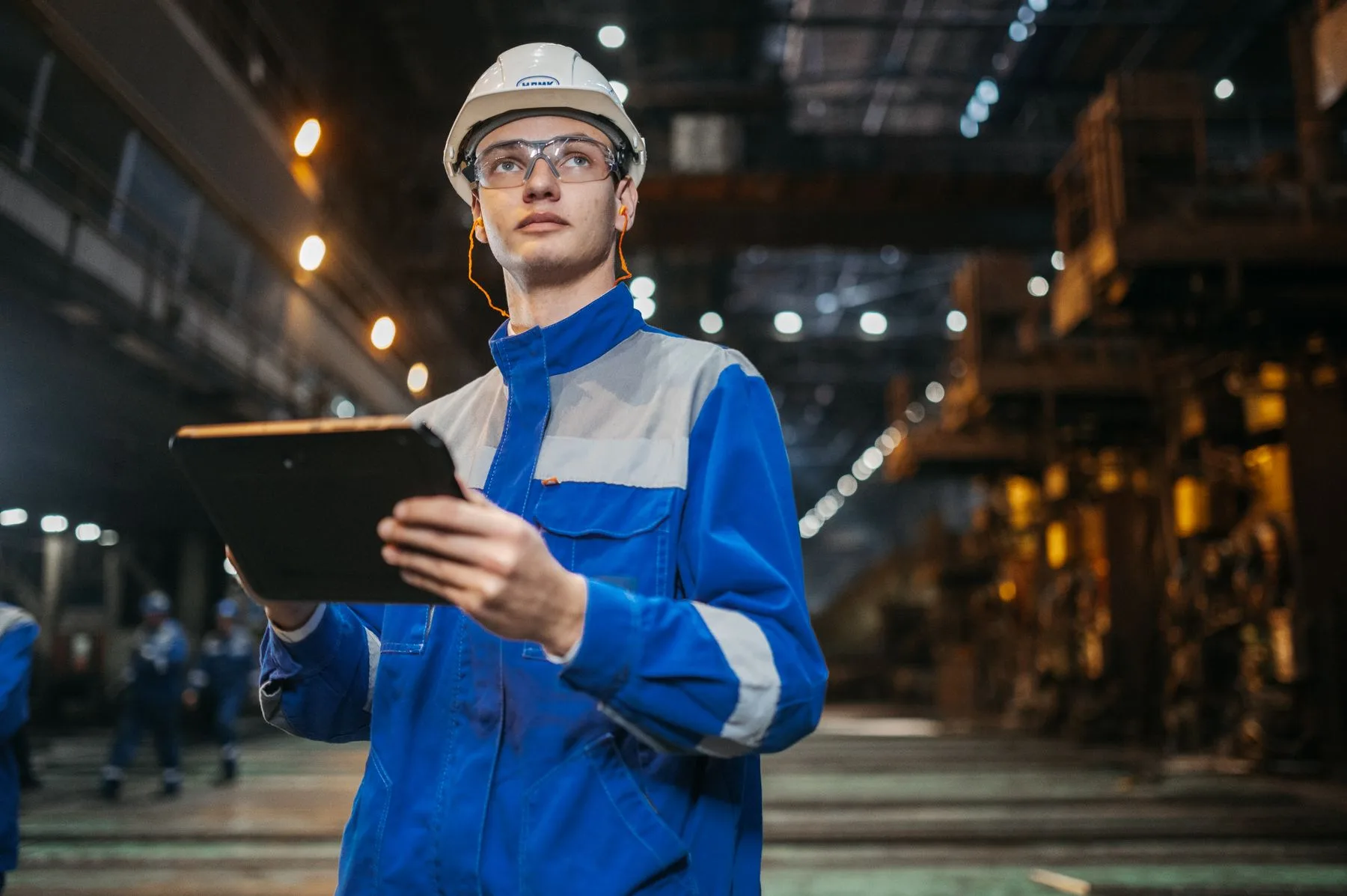 Industrial engineer using a tablet inside a production facility