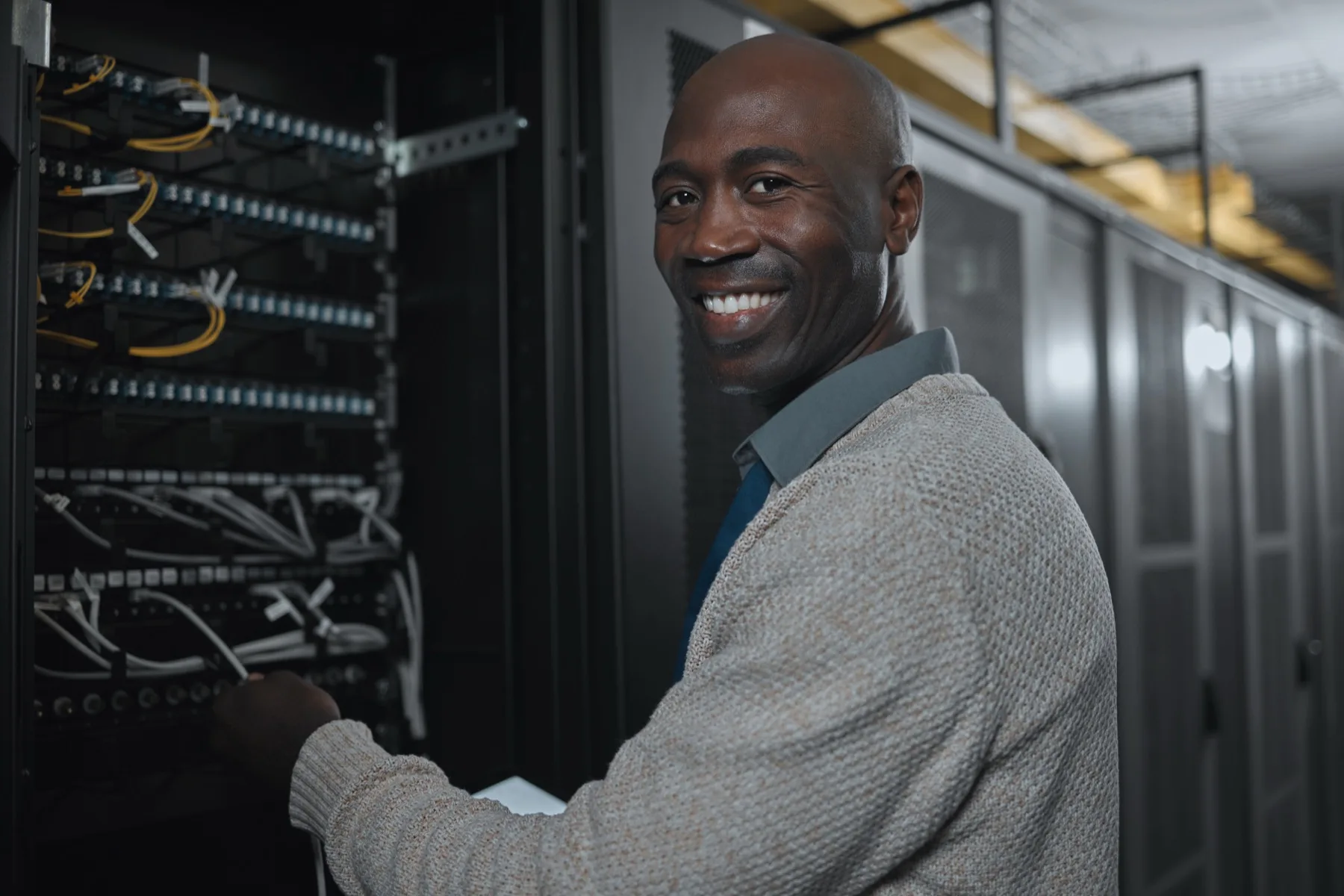 African network technician working on structured cabling inside a server room